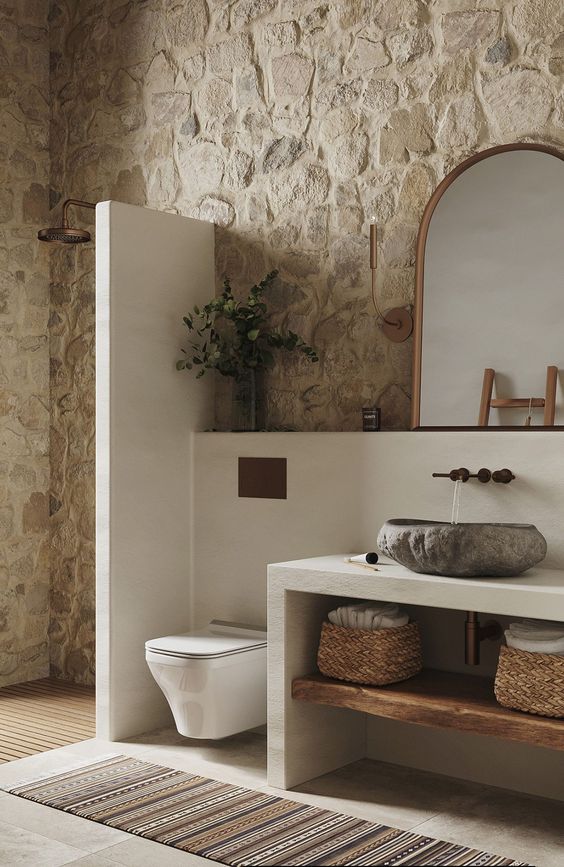 Salle de bain avec des murs en pierre naturelle avec des meubles blancs
