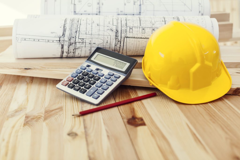 Une calculatrice et un casque de chantier sont posés sur une table.
